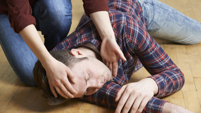 A man being placed in recovery position after accident